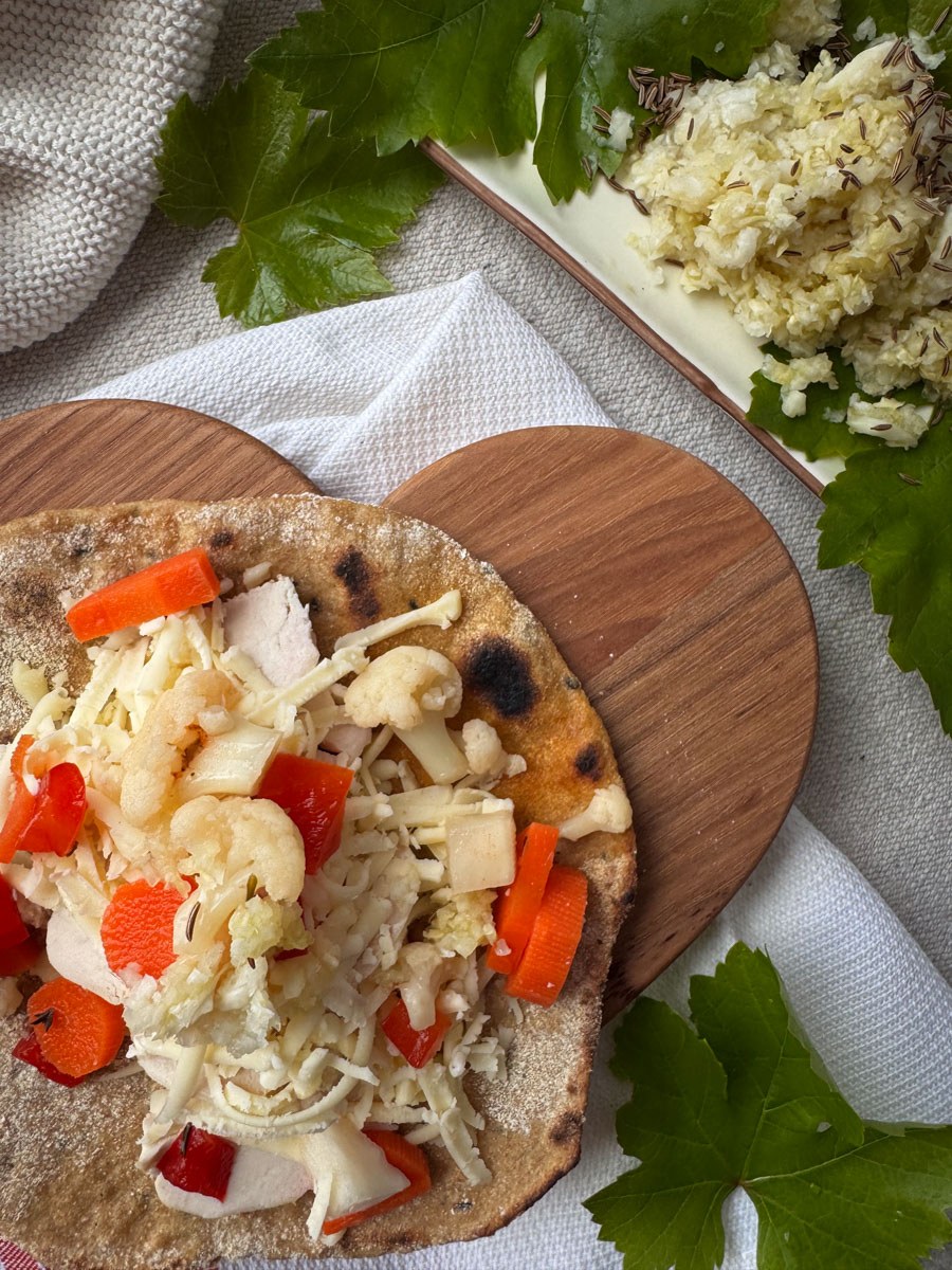 sourdough einkorn flatbreads topped with chicken, cheese, and fermented vegetables