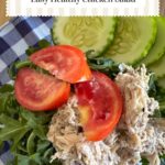 Healhy chicken salad served on a bed of arugula with tomatoes and cucumbers