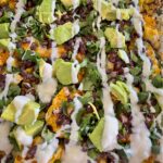 Layered cauliflower, black beans, avocado, cheese, and cilantro for lunch