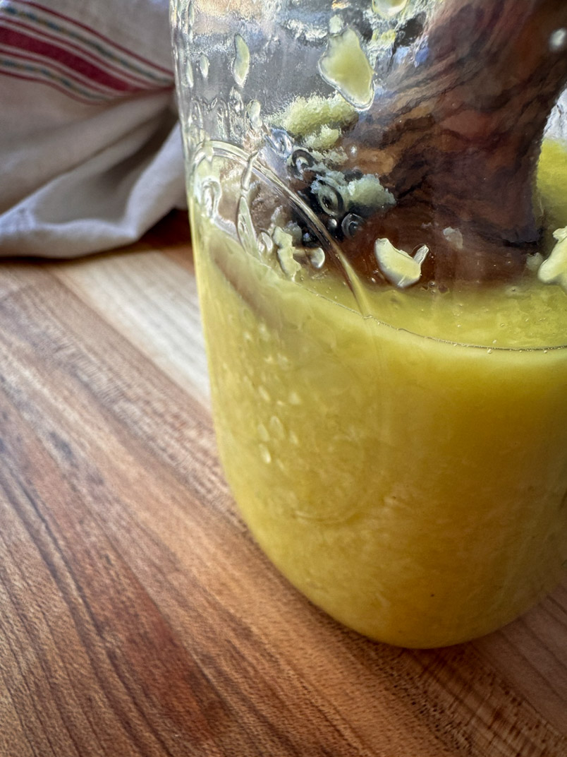 fermented ginger in a jar with a wooded kraut pounder fermented ginger in a jar with a wooded kraut pounder