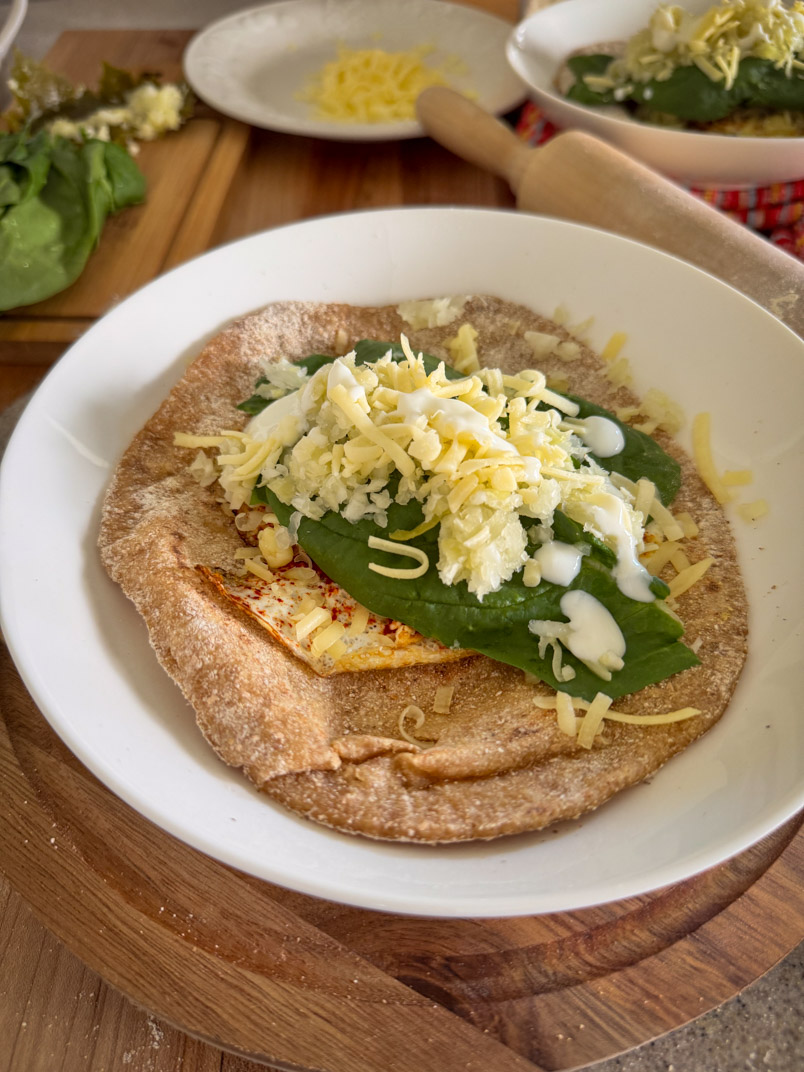 einkorn sourdough flatbread with fried egg, sauerkraut, cheese, turmeric and spinach