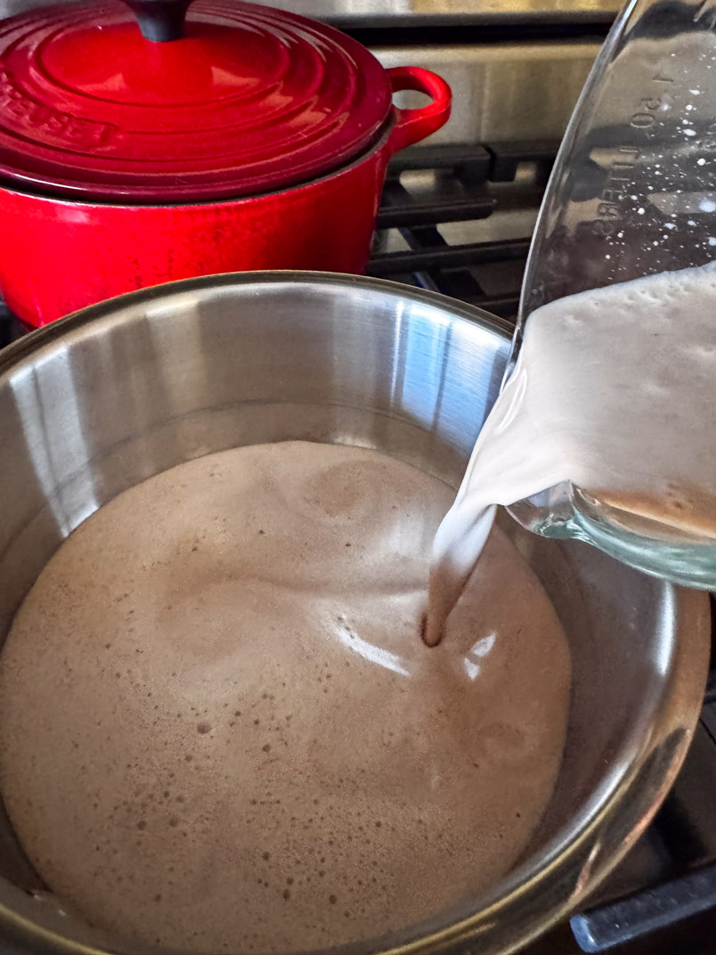 pouring hot date milk into the pan pouring hot date milk into the pan